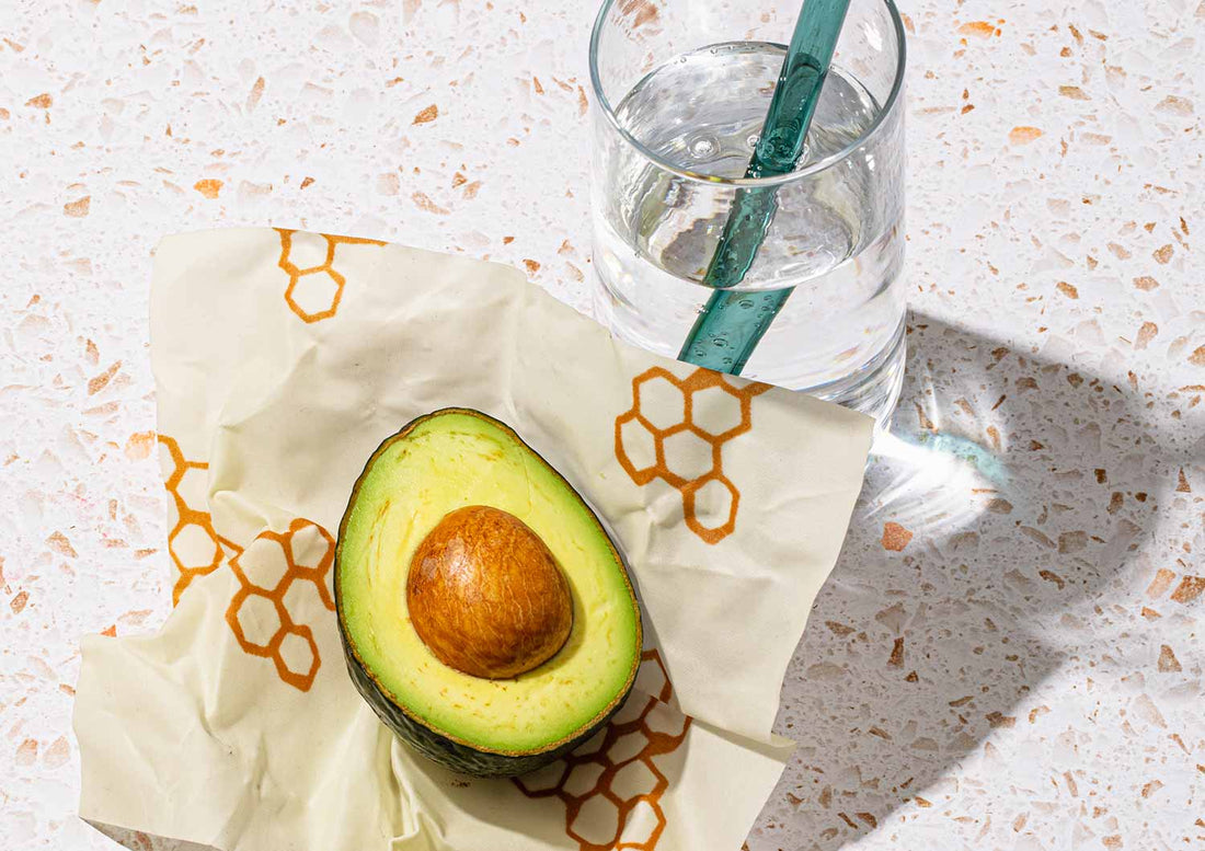 half an avocado and glass of water on bees wrap
